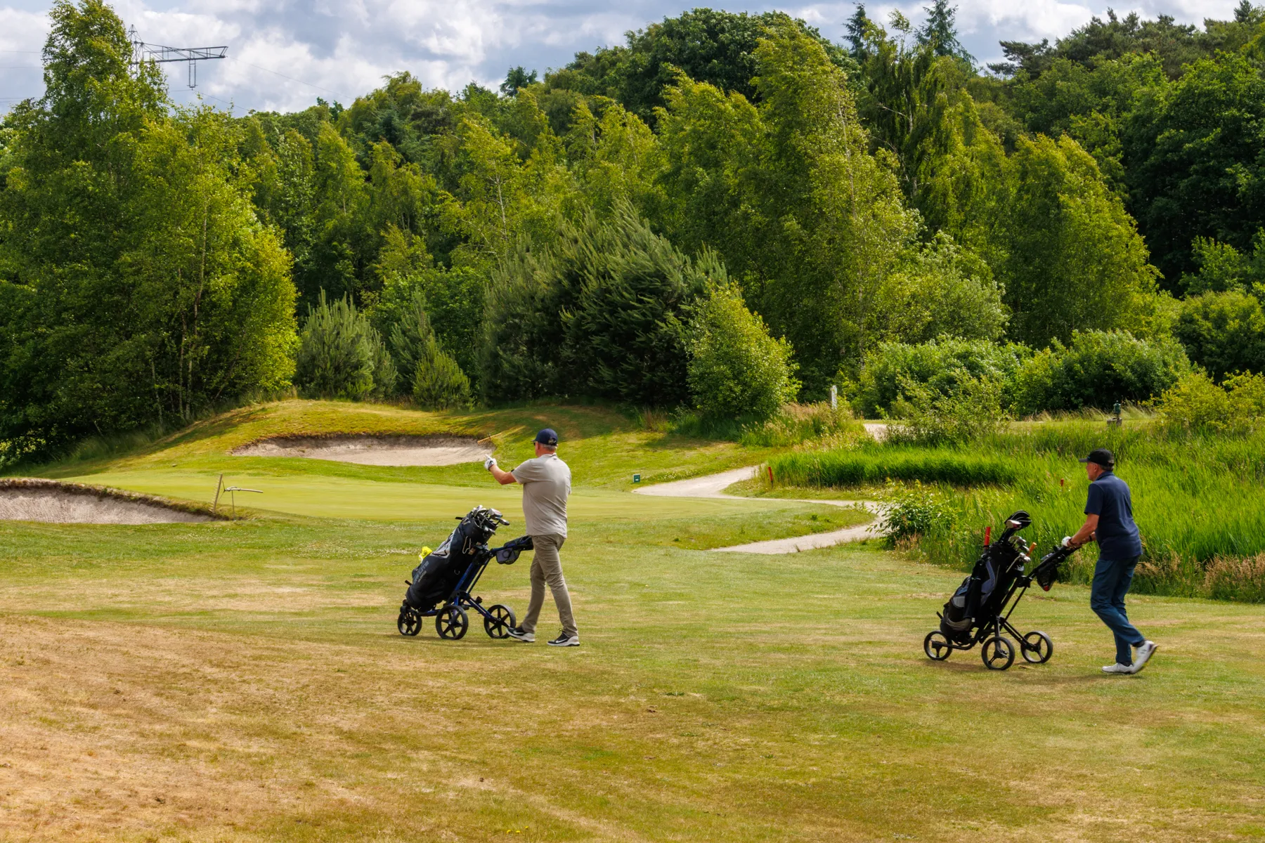 Golfers op weg naar de volgende afslagplaats op Gendersteyn, Veldhoven